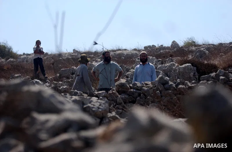 Israeli Jewish settlers from Brakha settlement hurl stones at Palestinians during clashes between residents of the Israeli Bracha settlement and Palestinian farmers from the West Bank Burin village on September 21, 2010....