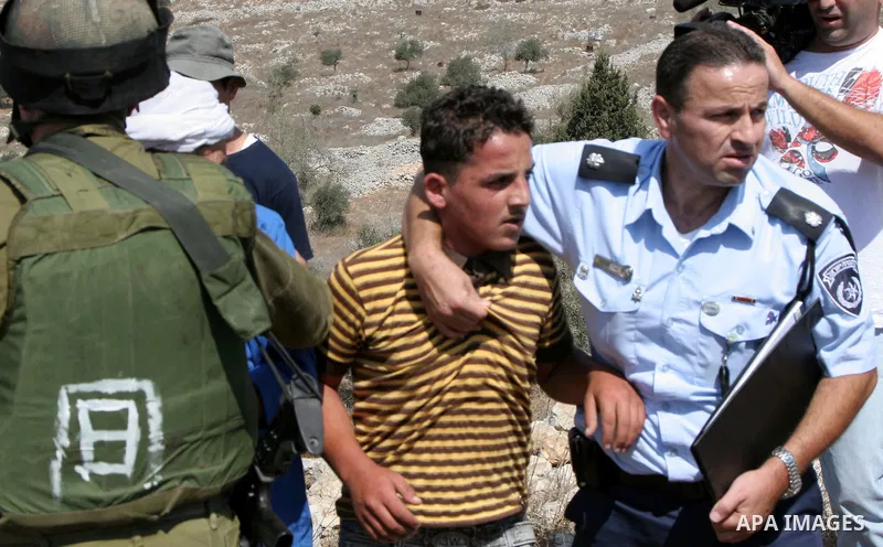 Israeli soldiers prevent Palestinian farmers from scuffling with Israeli settlers during clashes between residents of the Israeli Bracha settlement and Palestinian farmers from the West Bank Burin village on September 21...