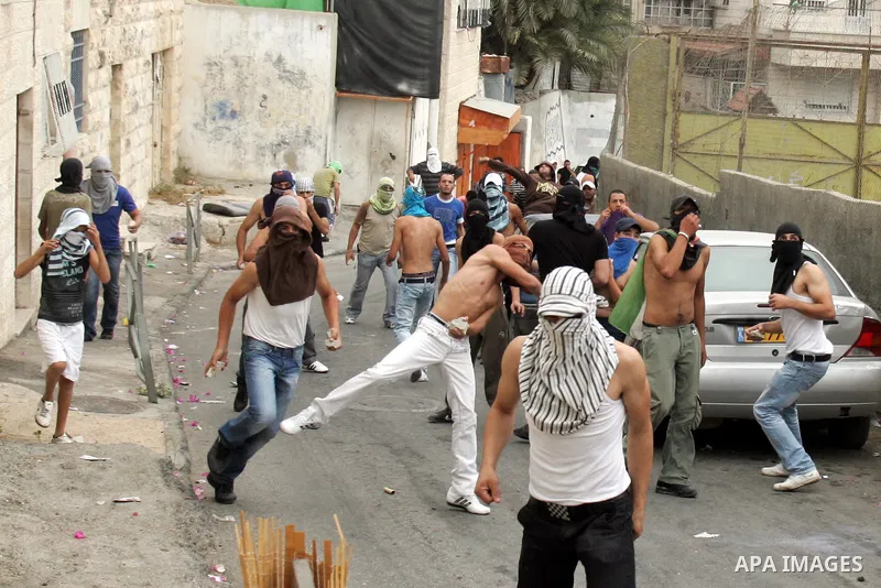Palestinian youths hurl stones at Israeli soldiers during the clashes in the east Jerusalem neighborhood of Silwan, Wednesday, Sept. 22, 2010. Violence erupted after a 32-year-old Palestinian laborer was killed by a priv...