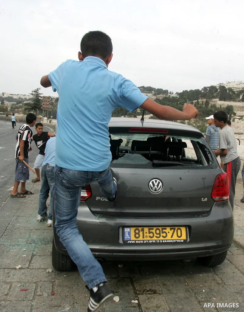 Palestinian youths destroy a car outside Jerusalem's old city following a day of clashes against Israeli forces on September 22, 2010 after a Jewish settlement guard shot dead a Palestinian man in the east Jerusalem neig...