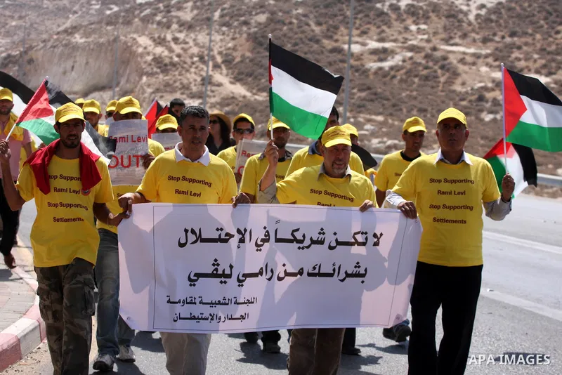 Members of the Palestinian Popular Committee for Boycotting Settlement Products protest outside an Israeli Shopping Center on the northern outskirts of the West Bank city of Ramallah, near the Adam settlement, to call fo...