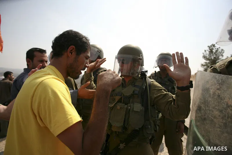 A Palestinian protestor confronts an Israeli soldier during a weekly demonstration against Israel's separation barrier in the West Bank village of Bilin, near Ramallah, on September 24, 2010. Photo by Eyad Jadallah