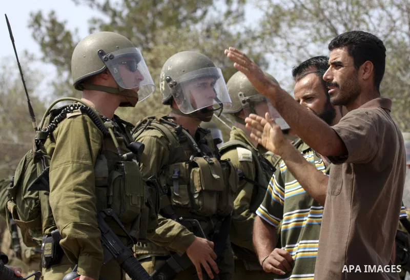 A Palestinian protestor confronts an Israeli soldier during a weekly demonstration against Israel's separation barrier in the West Bank village of Bilin, near Ramallah, on September 24, 2010. Photo by Eyad Jadallah