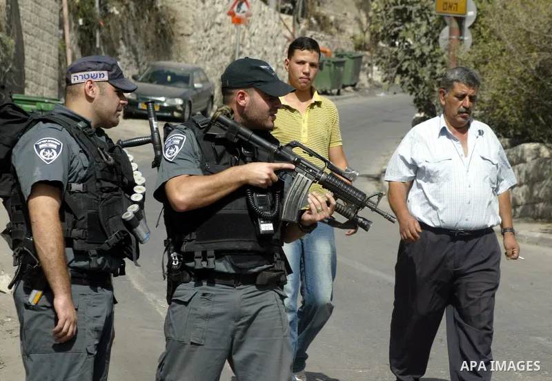 Palestinians walk past Israeli soldiers guarding in the streets of Jerusalem's mostly Arab east neighborhood of Silwan on September 28, 2010. Photo by Mahfouz Abu Turk
