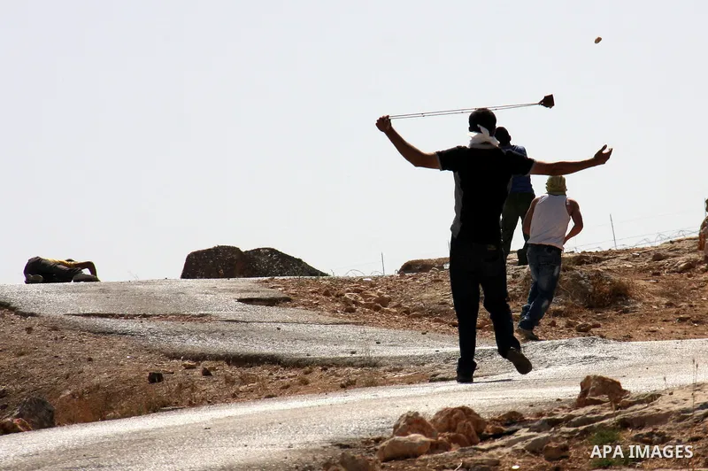 Palestinians youth hurl stones at Israeli soldiers during a protest against Israel's separation barrier in the West Bank village of Bilin near Ramallah, Friday, Oct. 1, 2010. U.S. Middle East envoy George Mitchell was sh...