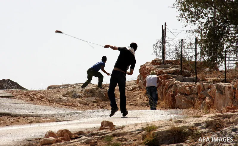 Palestinians youth hurl stones at Israeli soldiers during a protest against Israel's separation barrier in the West Bank village of Bilin near Ramallah, Friday, Oct. 1, 2010. U.S. Middle East envoy George Mitchell was sh...