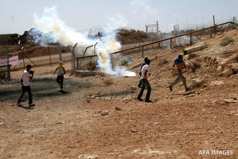 Palestinians youth hurl stones at Israeli soldiers during a protest against Israel's separation barrier in the West Bank village of Bilin near Ramallah, Friday, Oct. 1, 2010. U.S. Middle East envoy George Mitchell was sh...