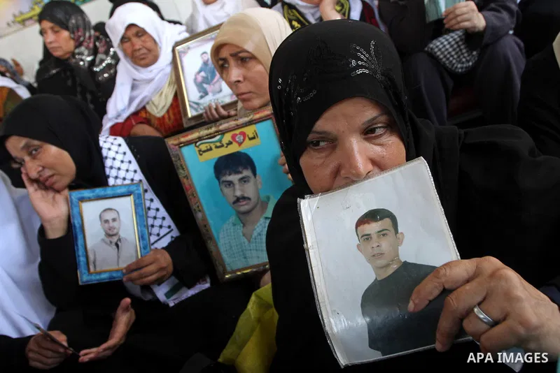 Palestinian women hold pictures of jailed relatives during a protest calling for the release of Palestinian prisoners from Israeli jails at the Red Cross office in Gaza City on October 4,2010 . Photo by Ashraf Amra