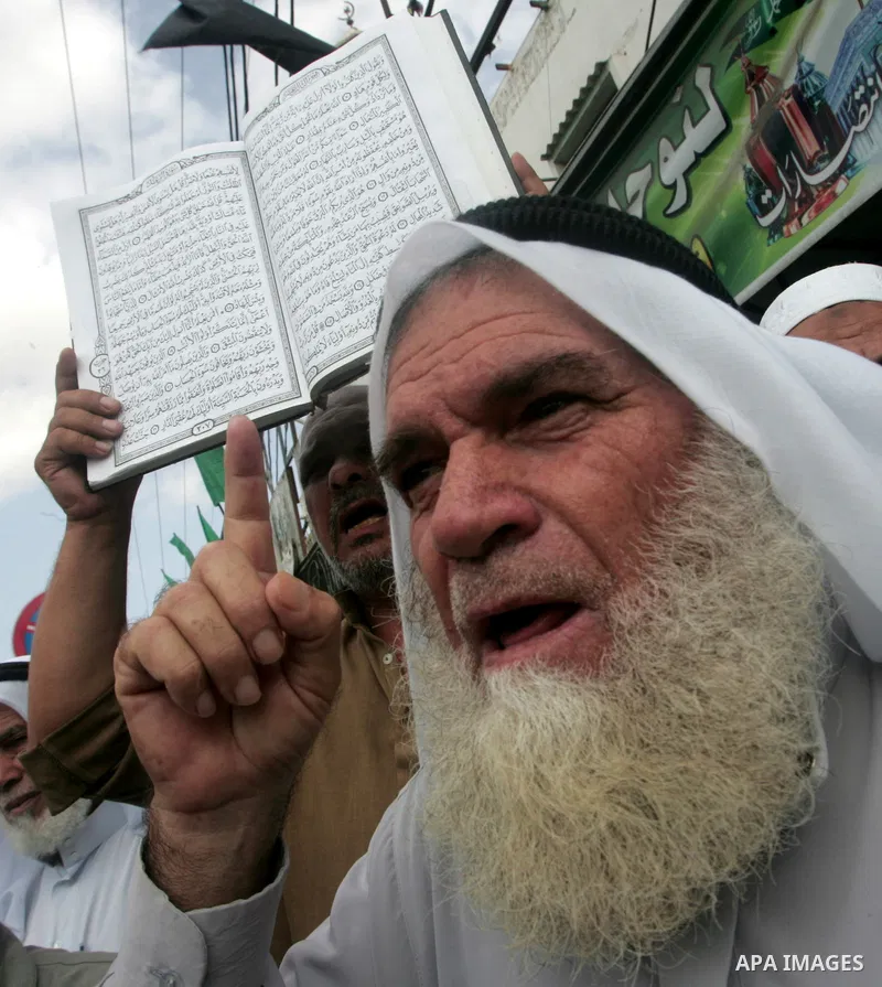 Palestinian men hold the holy Qur'an book during a demonstration to condemn the burning of mosque and Koran Sharif 'the holy Qur'an book' , in Rafah southern Gaza Strip on Oct. 5, 2010 . The Jewish settlers burned a mosq...