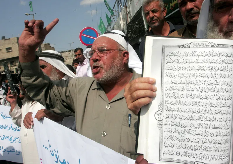 Palestinian men hold the holy Qur'an book during a demonstration to condemn the burning of mosque and Koran Sharif 'the holy Qur'an book' , in Rafah southern Gaza Strip on Oct. 5, 2010 . The Jewish settlers burned a mosq...