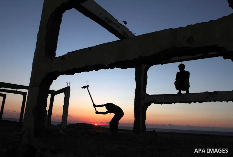 Palestinians work to re-manufacture cement from the remains of ruins of Palestinian buildings that were destroyed during the Israeli war against Hamas in the Gaza Strip, in the west of Beit Lahiya town in the northern Ga...