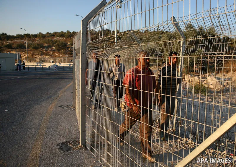 Palestinian workers walk to cross the Isreali controlled Modiin ( Bet seira ) checkpoint, between the West Bank and the Jewish settlement of Modiin Illit and all of Israeil , as they head to work in Israel and nearby set...