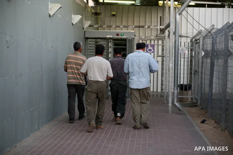 Palestinian workers walk to cross the Isreali controlled Modiin ( Bet seira ) checkpoint, between the West Bank and the Jewish settlement of Modiin Illit and all of Israeil , as they head to work in Israel and nearby set...
