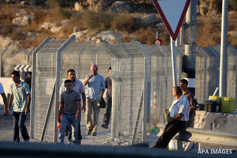 Palestinian workers wait to cross the Isreali controlled Modiin ( Bet seira ) checkpoint, between the West Bank and the Jewish settlement of Modiin Illit and all of Israeil , as they head to work in Israel and nearby set...