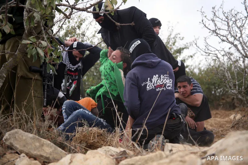 Israeli undercover forces arrest Palestinian boys during a demonstration by Palestinian, Israeli and foreign activists against the demolishing of farm land to be used in the construction of Jewish settlements near the ex...