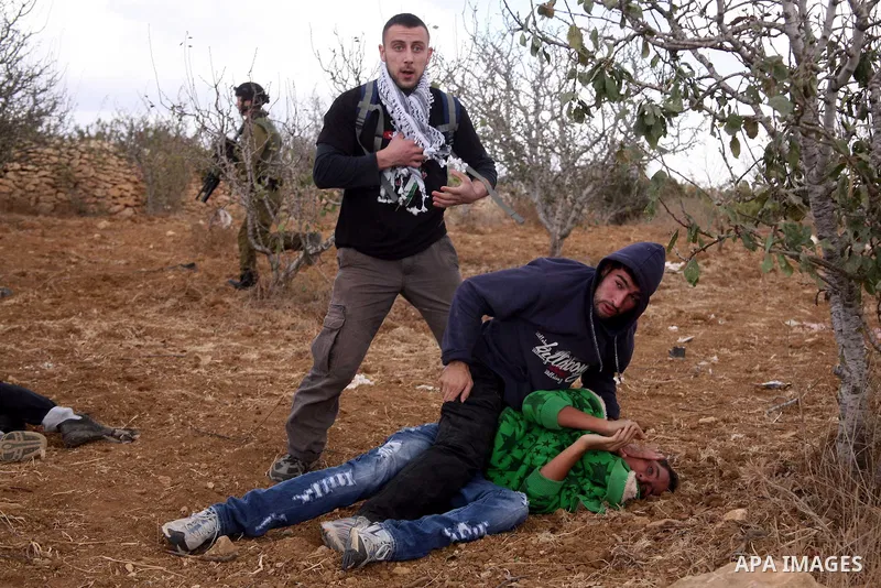 Israeli undercover forces arrest Palestinian boys during a demonstration by Palestinian, Israeli and foreign activists against the demolishing of farm land to be used in the construction of Jewish settlements near the ex...