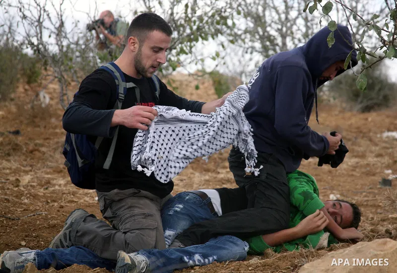 Israeli undercover forces arrest Palestinian boys during a demonstration by Palestinian, Israeli and foreign activists against the demolishing of farm land to be used in the construction of Jewish settlements near the ex...