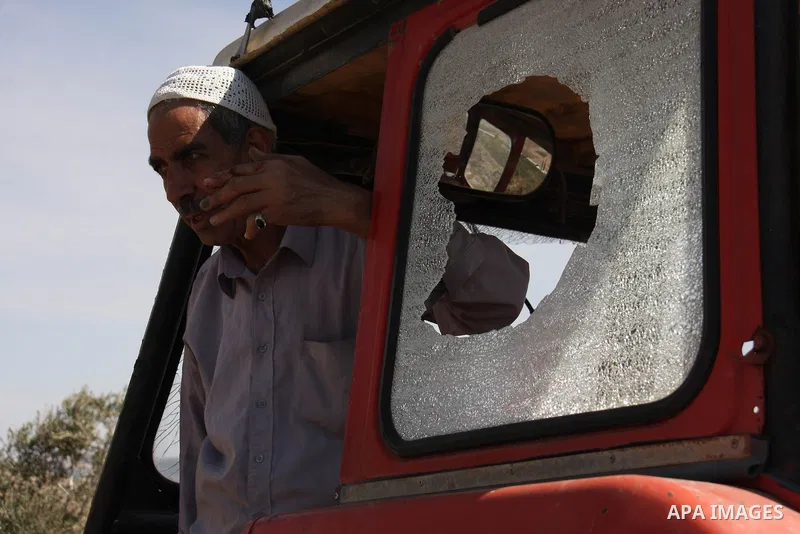 A Palestinian farmer stands in his truck crashed by Jewish settlers who attacked Palestinian farmers during pick olives in their agricultural fields in the West Bank village of Hawara, near Nablus on Oct. 10, 2010 . Phot...