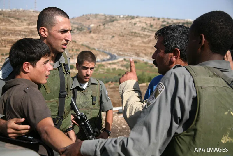 Israeli soldiers and border police officers scuffle with a Palestinian as a bulldozer demolishes a Palestinian house in the south of the West Bank city of Hebron on October 11,2010 . Photo by Najeh Hashlamoun