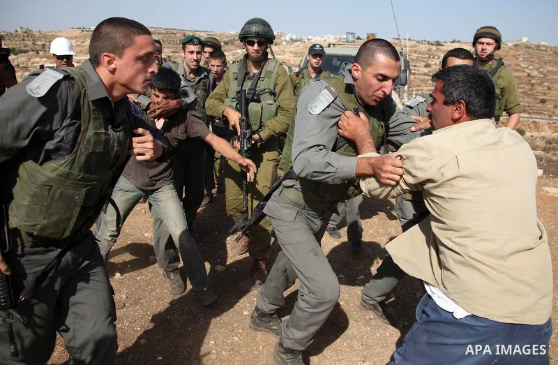 Israeli soldiers and border police officers scuffle with Palestinians as a bulldozer demolishes a Palestinian house in the south of the West Bank city of Hebron on October 11,2010 . Photo by Najeh Hashlamoun