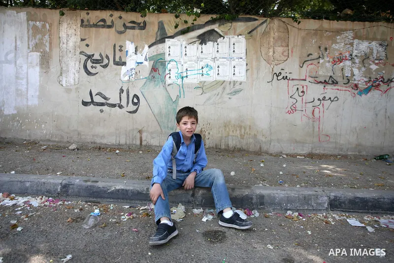 A Palestinian boy wearing school uniforms takes a rest in street , in West Bank city of Jericho , on Oct. 11.2010 . Jericho is one of the oldest continuously inhabited cities in the world, with evidence of settlement dat...