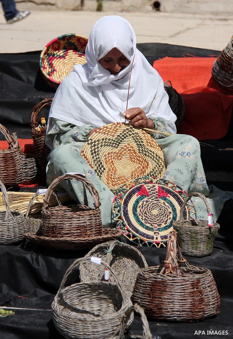 An Elderly Palestinian woman paints a hay with the colors of Palestinian flag to make a traditional dish during a ceremony, in the West Bank town of Salfit, Wednesday ,Oct. 13, 2010. Photo by Wagdi Eshtayah