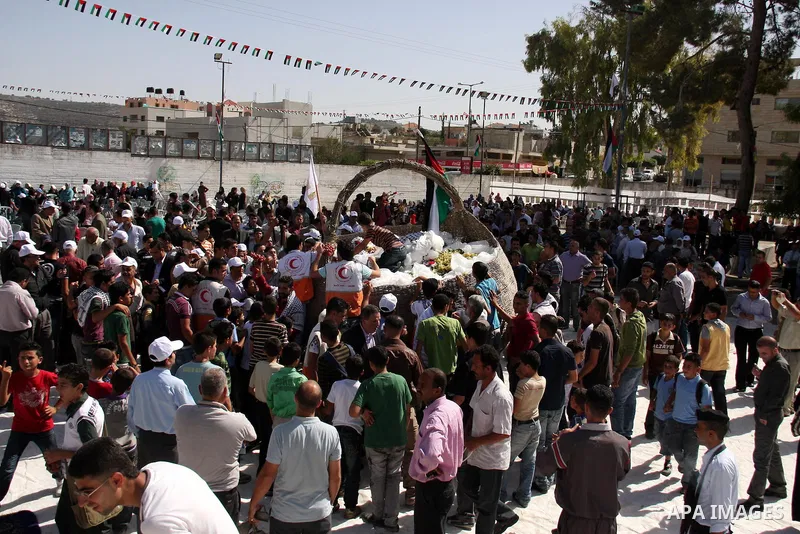 Palestinians gather around the basket with a length of three meters made from olives branches during a ceremony, in the West Bank town of Salfit, Wednesday ,Oct. 13, 2010. Photo by Wagdi Eshtayah