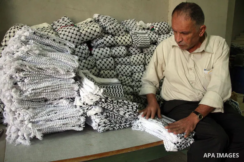 A Palestinian man works at a Kefiyeh (traditional Arab scarf) factory in the West Bank city of Hebron on October 14, 2010. The Herbawi family factory once supplied much of the West Bank and Gaza with the scarves, or keff...