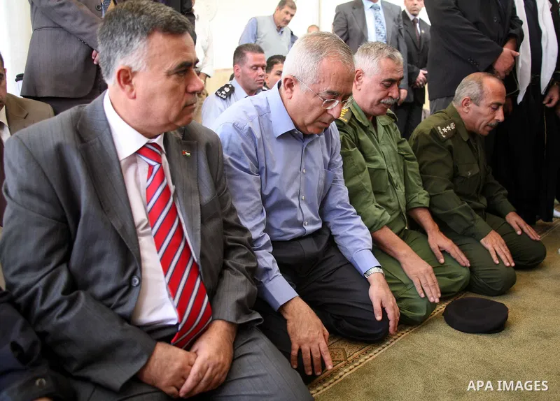 Palestinian prime minister Salam Fayyad attends Friday prayer among Palestinian officials at a West Bank mosque that was desecrated and burnt by jewish settlers in the village of Beit Fajjar, south of Bethlehem, on Octob...