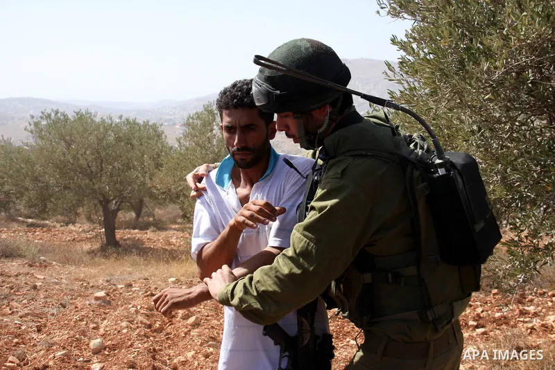 A Palestinian man is detained by Israeli soldiers after they arrive to pacify the situation after Israeli settlers attacked Palestinian farmers while they collect Olive at Azmout village near the West Bank City of Nablus...