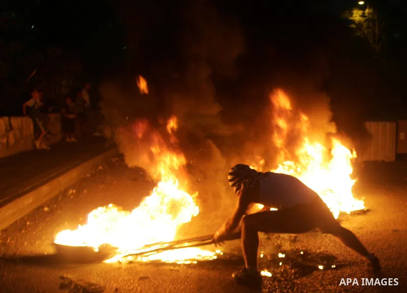 A Palestinian youth adds a piece of cardboard to a fire set ablaze after throwing stones at Israeli border police in the East Jerusalem neighbourhood of Silwan on Oct. 17,2010 . Photo by Mahfouz Abu Turk