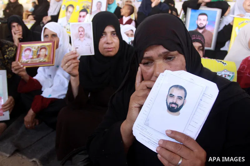 Palestinian women and children hold pictures of jailed relatives during a protest calling for the release of Palestinian prisoners from Israeli jails at the Red Cross office in Gaza City on Oct. 18,2010 . Photo by Mohamm...