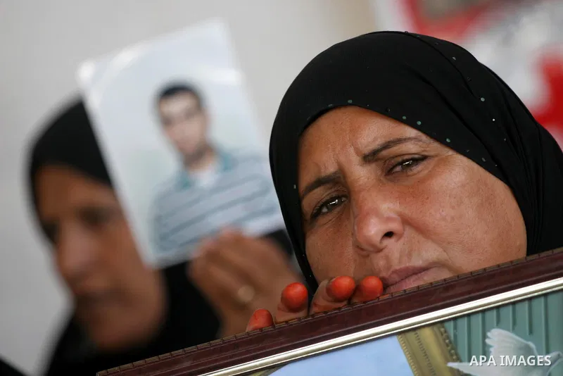 Palestinian women and children hold pictures of jailed relatives during a protest calling for the release of Palestinian prisoners from Israeli jails at the Red Cross office in Gaza City on Oct. 18,2010 . Photo by Mohamm...