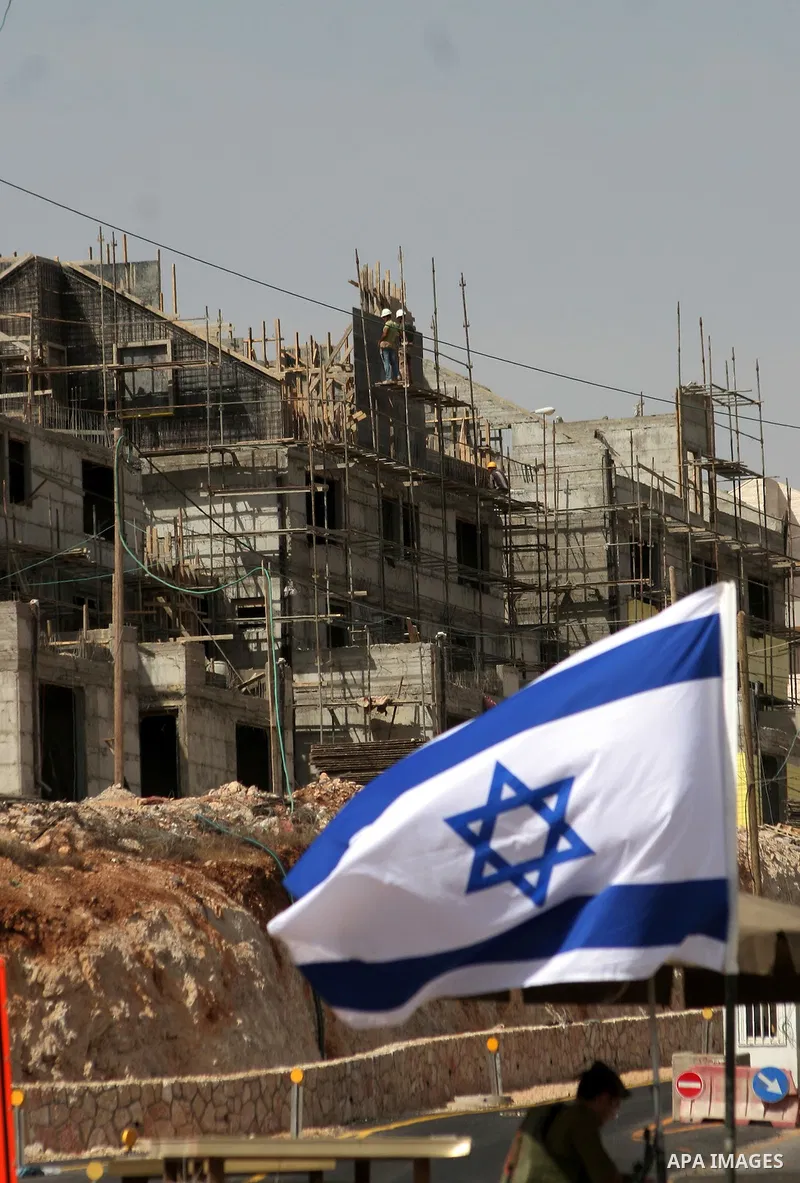 Palestinians work on a housing unit under construction site in settlement of Kiryat Arba , close to the West Bank town of Hebron , on Oct 17,2010 . Two days after reported plans to build 238 new settler homes in annexed...