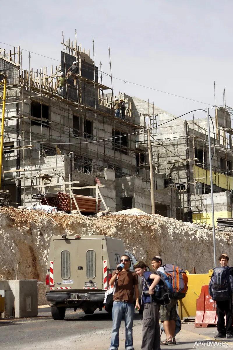 Palestinians work on a housing unit under construction site in settlement of Kiryat Arba , close to the West Bank town of Hebron , on Oct 17,2010 . Two days after reported plans to build 238 new settler homes in annexed...