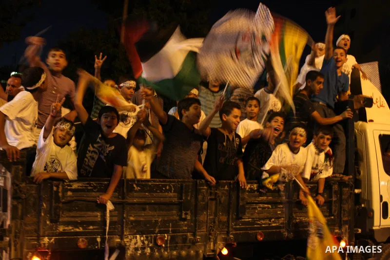 Palestinian youths wave with Palestinian flags and the flags of Fatah party during a march in support to the Palestinian President Mahmoud Abbas, in the West Bank city of Ramallah, on Oct. 18, 2010. Photo by Issam Rimawi