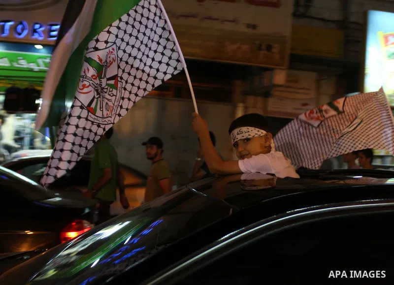 Palestinian youths wave with Palestinian flags and the flags of Fatah party during a march in support to the Palestinian President Mahmoud Abbas, in the West Bank city of Ramallah, on Oct. 18, 2010. Photo by Issam Rimawi