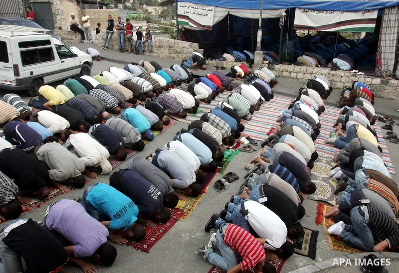 Palestinians attend Friday prayer outside a protest tent on October 22, 2010 in the flashpoint Arab east Jerusalem neighbourhood of Silwan, home to some hundreds of Jewish settlers.. Photo by Mahfouz Abu Turk
