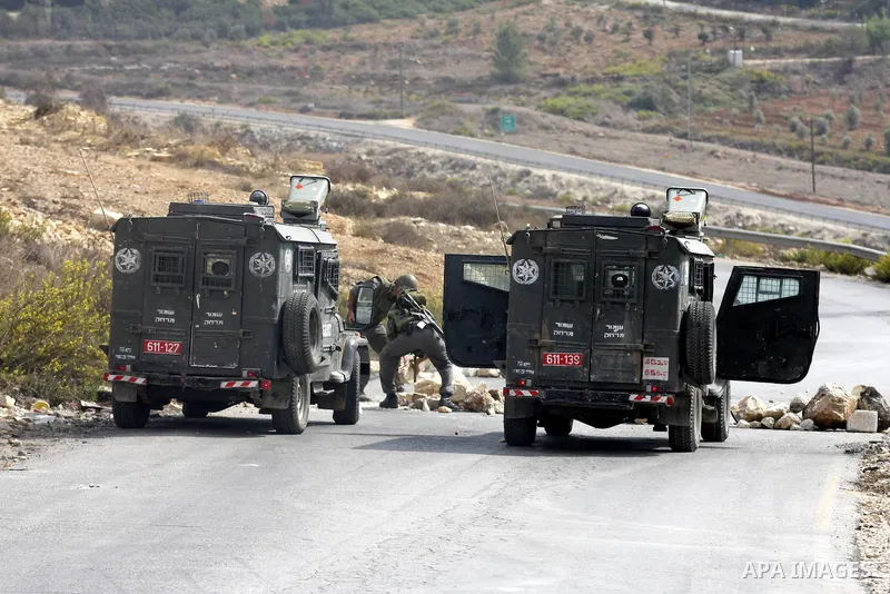 Israeli border policemen carry away stones from a street during clashes in the West Bank village of Nabi Saleh, on 22 October 2010. Palestinians protest weekly against the neighbouring Jewish settlement of Halamish. Phot...