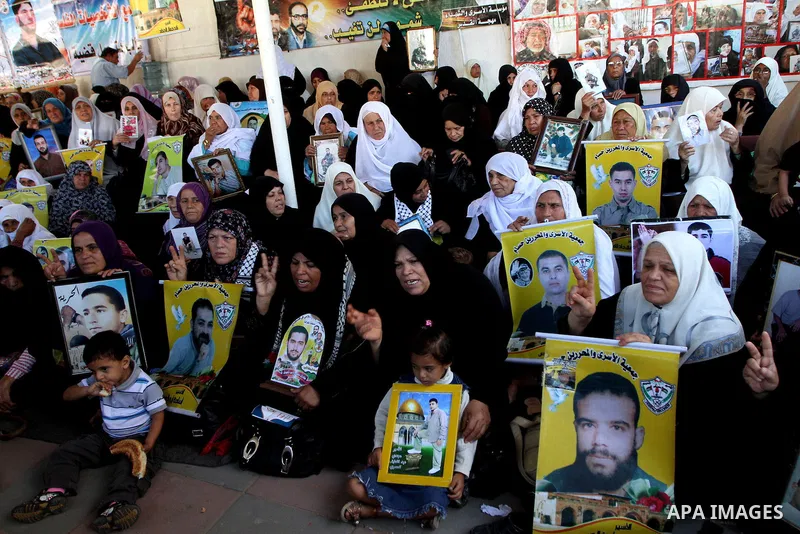 Palestinian women and children hold pictures of jailed relatives during a protest calling for the release of Palestinian prisoners from Israeli jails at the Red Cross office in Gaza City on Oct. 25,2010 . Photo by Ashraf...