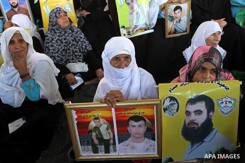 Palestinian women and children hold pictures of jailed relatives during a protest calling for the release of Palestinian prisoners from Israeli jails at the Red Cross office in Gaza City on Oct. 25,2010 . Photo by Ashraf...