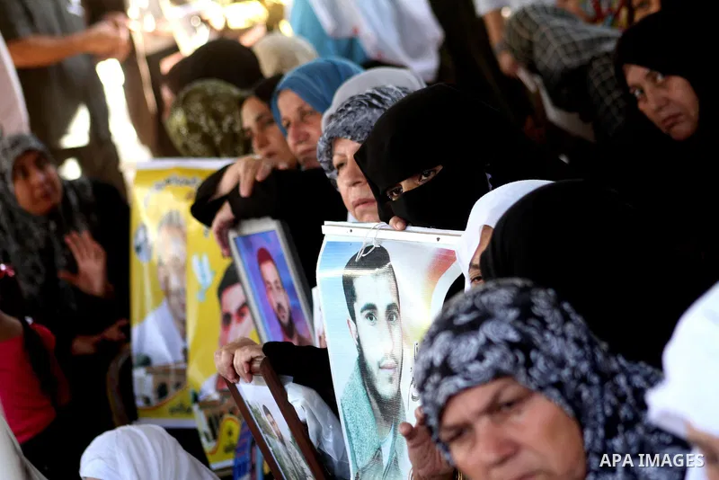 Palestinian women and children hold pictures of jailed relatives during a protest calling for the release of Palestinian prisoners from Israeli jails at the Red Cross office in Gaza City on Oct. 25,2010 . Photo by Ashraf...