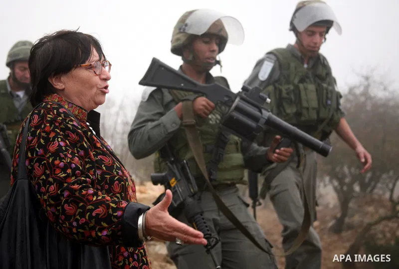 Israeli soldiers stand guard during a demonstration by Palestinian, Israeli and foreign activists against the demolishing of farm land to be used in the construction of Jewish settlements near the existing Israeli settle...