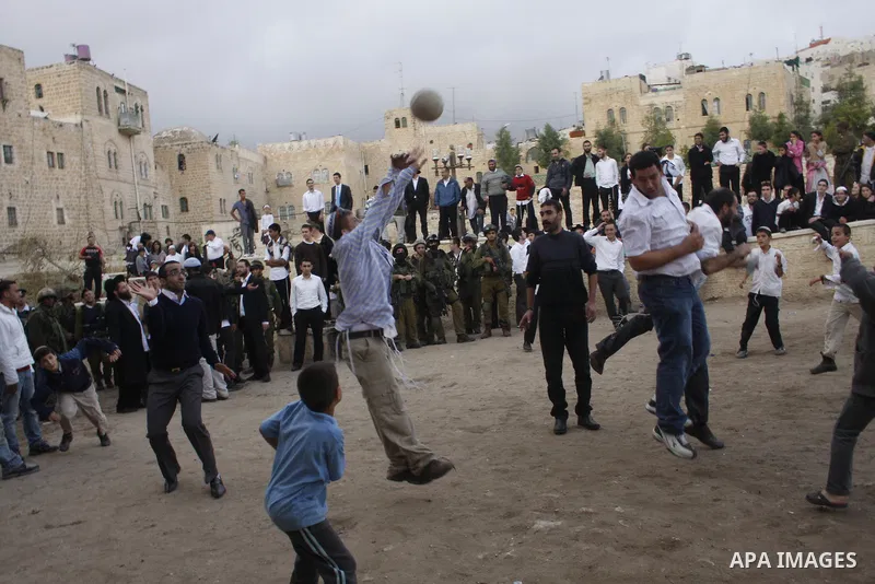 An Orthodox Jewish throws the ball during a friendly football match between Palestinian and Jewish settler youth in the old sector of the restive West Bank city of Hebron in the Israeli occupied West Bank on October 30,...