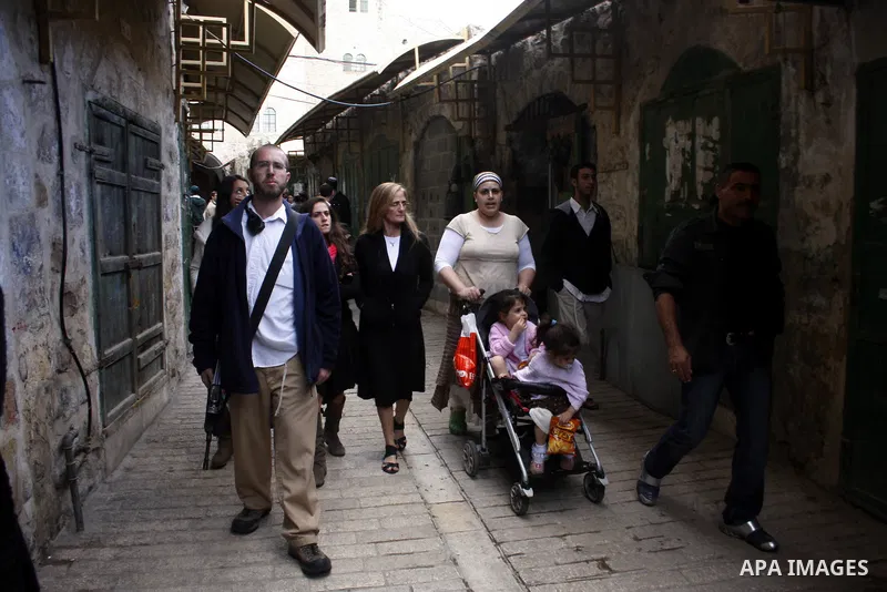 Jewish settlers walk by in the Kiryat Arba settlement of the West Bank City of Hebron, on 30 October 2010. Organizers expect thousands of Jews to converge on the West Bank town of Hebron on for the Sabbath in order to ce...