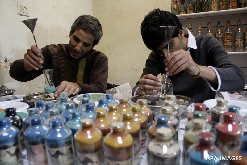 The painter , Mohammed Awawdeh and his assistant paint with sand in a suburb of the Old City of Hebron on Oct. 31,2010 . Awawdeh tries through his drawings is promotion and support the tourism in the old town and enters...