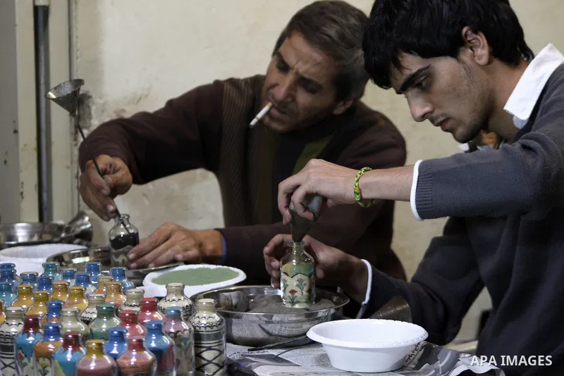The painter , Mohammed Awawdeh and his assistant paint with sand in a suburb of the Old City of Hebron on Oct. 31,2010 . Awawdeh tries through his drawings is promotion and support the tourism in the old town and enters...