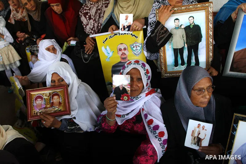 Palestinian women and children hold pictures of jailed relatives during a protest calling for the release of Palestinian prisoners from Israeli jails at the Red Cross office in Gaza City on November 1,2010 . Photo by Ash...