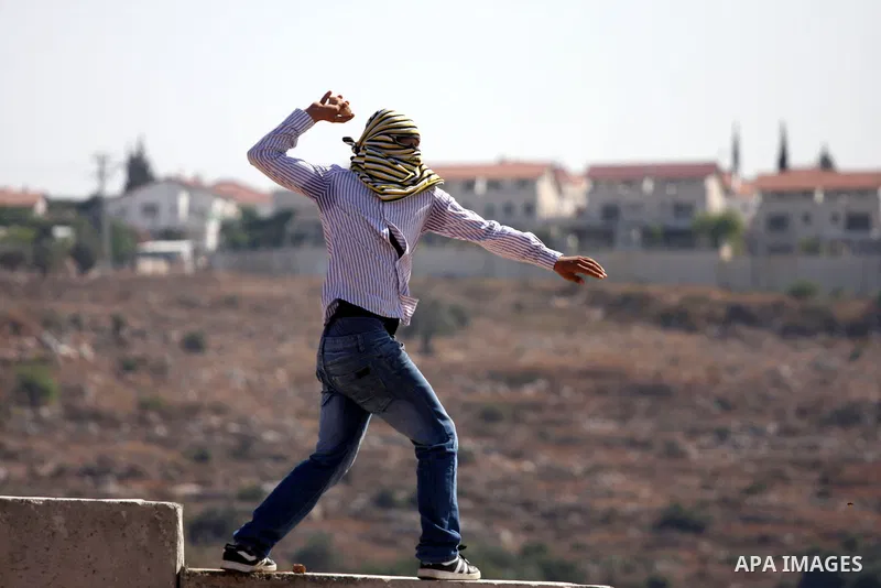 A Palestinian protester hurls stones at Israeli soldiers during clashes in the West Bank village of Nilin, near the Palestinians city of Ramallah,on Nov. 5, 2010. Clashes erupted during the weekly demonstrations, which a...