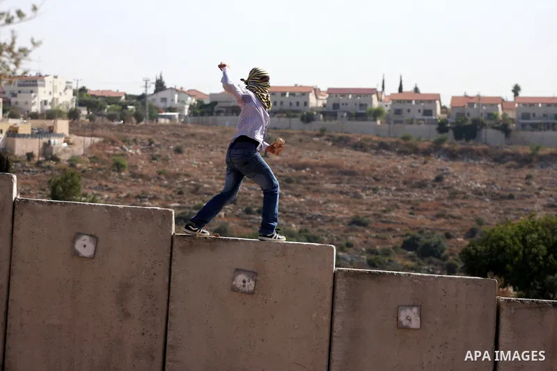 A Palestinian protester hurls stones at Israeli soldiers during clashes in the West Bank village of Nilin, near the Palestinians city of Ramallah,on Nov. 5, 2010. Clashes erupted during the weekly demonstrations, which a...
